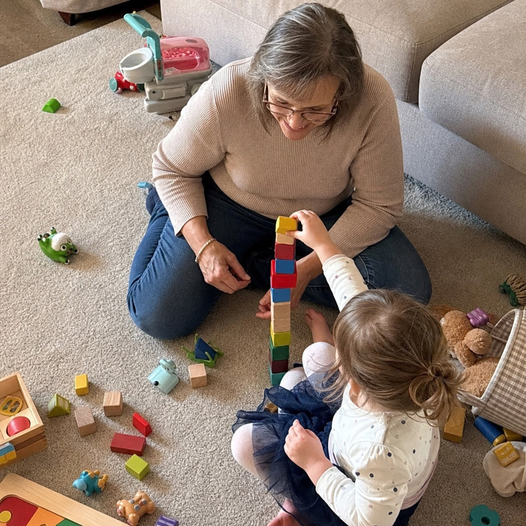 On the floor building a block tower with her granddaughter